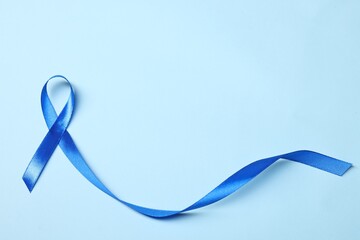 Blue ribbon on light background, top view with space for text. Prostate cancer awareness