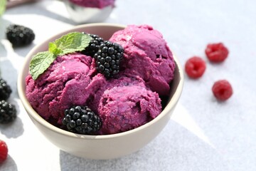 Delicious blackberry sorbet, mint and fresh berries on grey table, closeup. Space for text