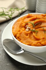 Delicious mashed sweet potatoes served on gray textured table, closeup
