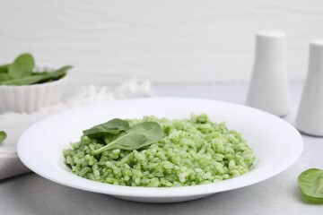 Delicious spinach risotto on light grey table, closeup