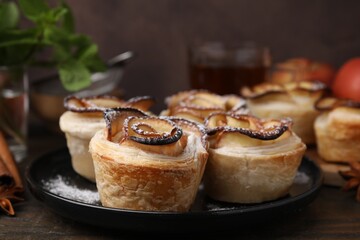 Freshly baked apple roses on wooden table, closeup