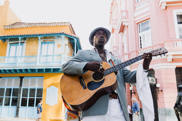 Black Man musician playing guitar on the street in La Havana Cuba in Latin America Caribbean city