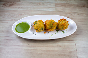 aalu bonda is an indian pakora or batata vada served with green chutney