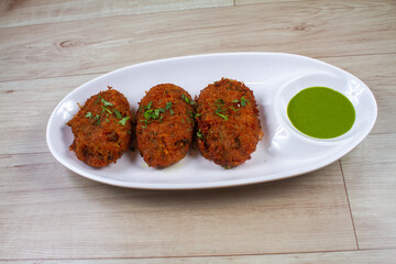 Bhajyanche katlet Maharashtrian popular nutritious breakfast, isolated over a rustic wooden background, selective focus