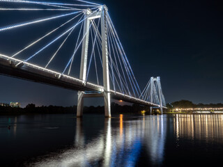 A bridge over a wide river with night illumination.