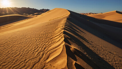 Majestic sand dunes under a clear sky, with sunlight casting dramatic shadows on the desert landscape