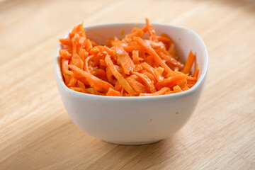 carrot salad middle eastern style in a small bowl served on a wooden table middle eastern style