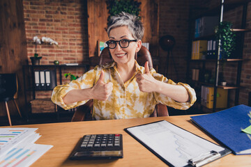 Photo of attractive successful retired woman accountant economist thumb up two hand nice job...