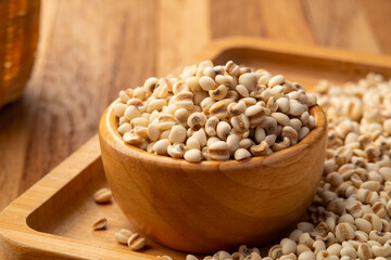 Raw Job's Tears,Coix lacryma-jobi Or Millet Seed on wooden bowl background.