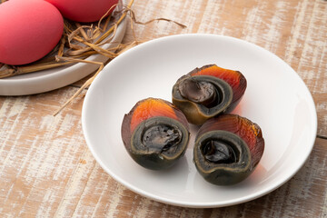 Half sliced Century egg in white plate, Pink color preserved eggs.