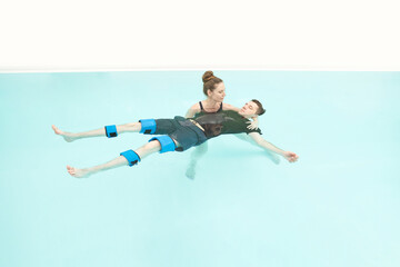 Two people in pool. Watsu man. Blue water rehabilitation massage. Aqua therapy exercise. Physio...