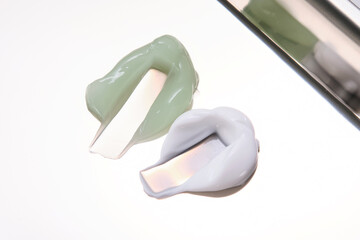 White and green cream on a stainless steel surface.