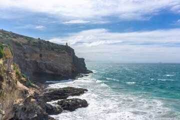 A stunning lighthouse perched on the dramatic cliffs of Otago's coast, New Zealand. Overlooking the Pacific Ocean, this spot offers breathtaking views, perfect for summer outings, birdwatching