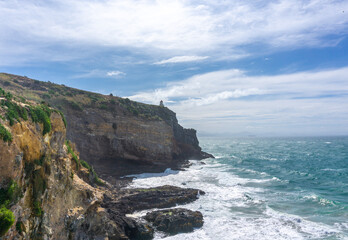 A stunning lighthouse perched on the dramatic cliffs of Otago's coast, New Zealand. Overlooking the Pacific Ocean, this spot offers breathtaking views, perfect for summer outings, birdwatching