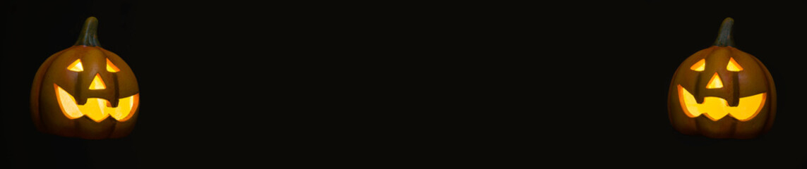 black background screen with a halloween pumpkin on each side of the image