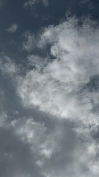 An airplane in the sky flies among moving clouds