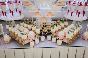 A table with a variety of desserts and drinks, including a sign that says 