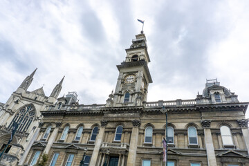 Fototapeta premium Gothic splendor of Dunedin's cathedral and its historic train station, iconic landmarks on New Zealand's South Island. Perfect for architecture enthusiasts, urban explorers, and history church towers