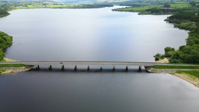 A car crossing a bridge on a rural irish lake on a sunny day. Blessington, Wicklow, Ireland