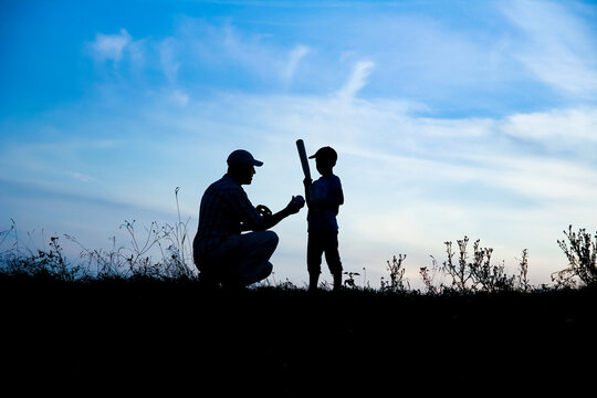 A Happy child with parent playing baseball concept in park in nature