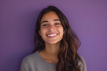 Fototapeta premium Young woman smiling against purple background
