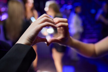 Hands Forming a Heart Shape in the Midst of a Vibrant and Joyful Celebration Event