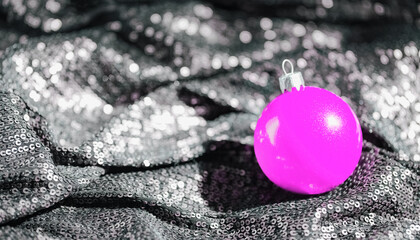 Bright pink christmas bauble on shimmering black background. Minimal style xmas composition. Celebration and party concept. Copy space