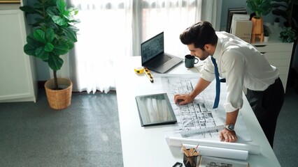 Civil engineer talk to manager by using phone while looking at tablet and standing at meeting room. Professional architect celebrate successful project while planning by using tablet. Alimentation.