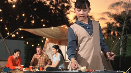 Family gather celebrate holiday, Adorable child grill food for family member. Outdoor camping...