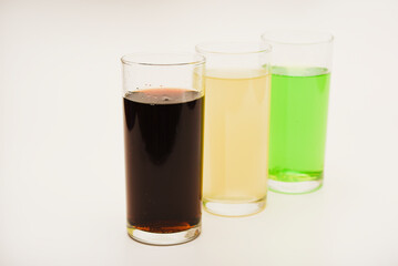 Glass glasses with soda on a white background. Juice in three glasses.