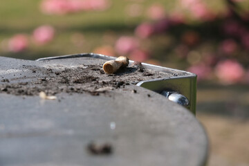 Un mozzicone di sigaretta su un posacenere all'aperto.