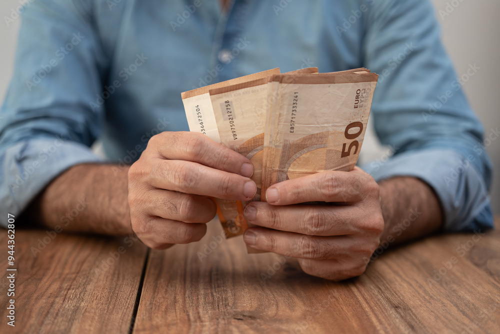 Poster man entrepreneur holds euro banknotes counting money with attention preparing cash for paying salary