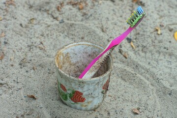 one  toothbrush plastic pink stands in empty coffee ceramic old white dirty beautiful broken...
