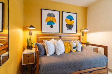 A modern, minimalist bedroom with two single beds featuring wooden frames and gray quilted bedding.