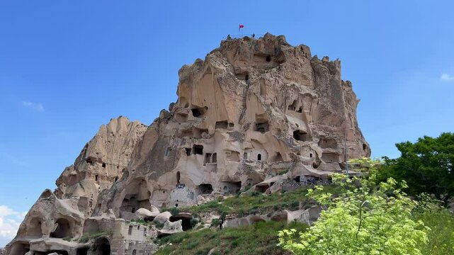 Uchkhisar fortress city. The famous Uchhisar cave castle in Cappadocia. The big stone town of Uchhisar in Turkey in hot summer weather. 4K