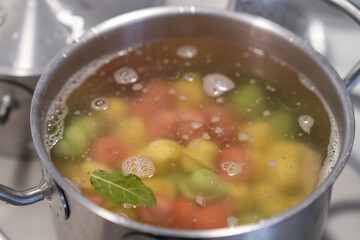 In a pot, colorful dumplings are being boiled. Preparing lunch or dinner