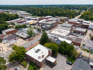 Obraz premium Daytime Drone Images of Downtown Louisburg North Carolina on a Sunny Day, Featuring the Historic Downtown Area, The Franklin County Courthouse, and The Tar River. 