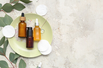 Composition with cosmetic products and eucalyptus branches on light background