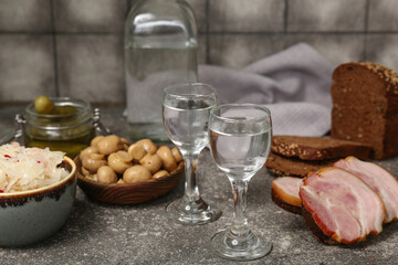 Shots with cold vodka and snacks on table