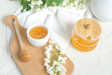 Composition with sweet honey and acacia flowers on light background, closeup