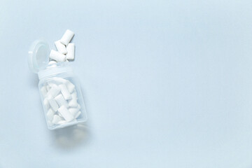 Jar with tasty chewing gums on grey background