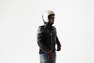 Bearded young man wearing helmet and black jacket posing indoor. Mock-up.