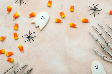 Tasty Halloween candy corns, skeleton hands and cookies on beige background, closeup