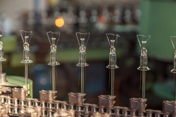 Conveyor line that puts tungsten filament on tube wires.