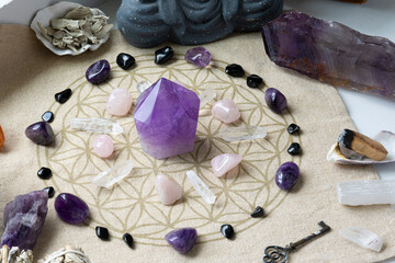 A top view image of several crystals arranged on a sacred geometry grid cloth for the purpose of spiritual healing.