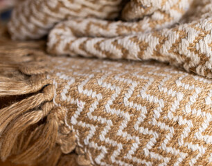 Rustic cotton zig zag woven blanket with beige bangs.