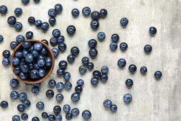Bowl with fresh blueberries on grey background