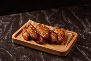 Succulent and Deliciously Glazed Asian Style Chicken Wings Served on a Wooden Platter