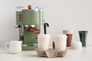 Holder with takeaway cups of tasty coffee on white background