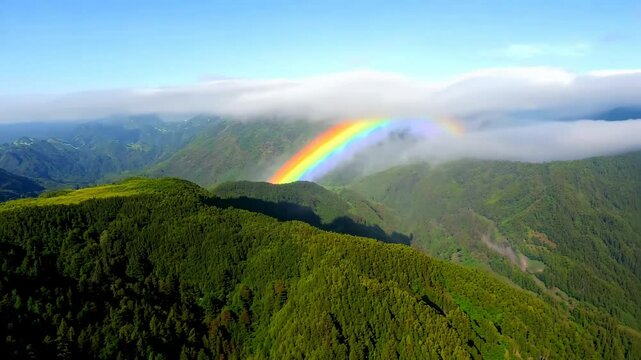 Animation of mountains with colorful rainbow in cloudy sky over field. Nature landscape after storm. Spring morning. St Patrick Day holiday symbol